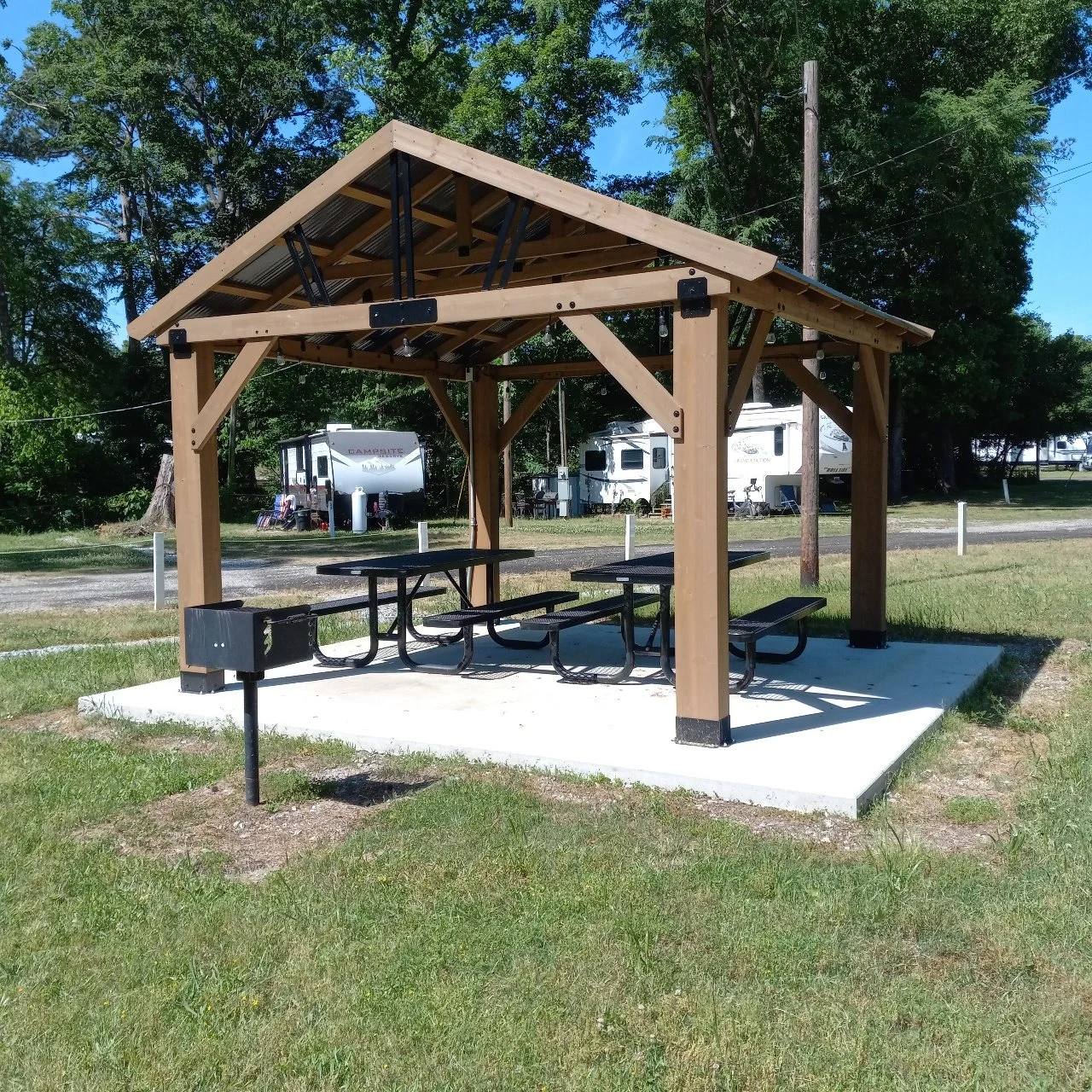 Covered picnic pavilion with a picnic table and grill